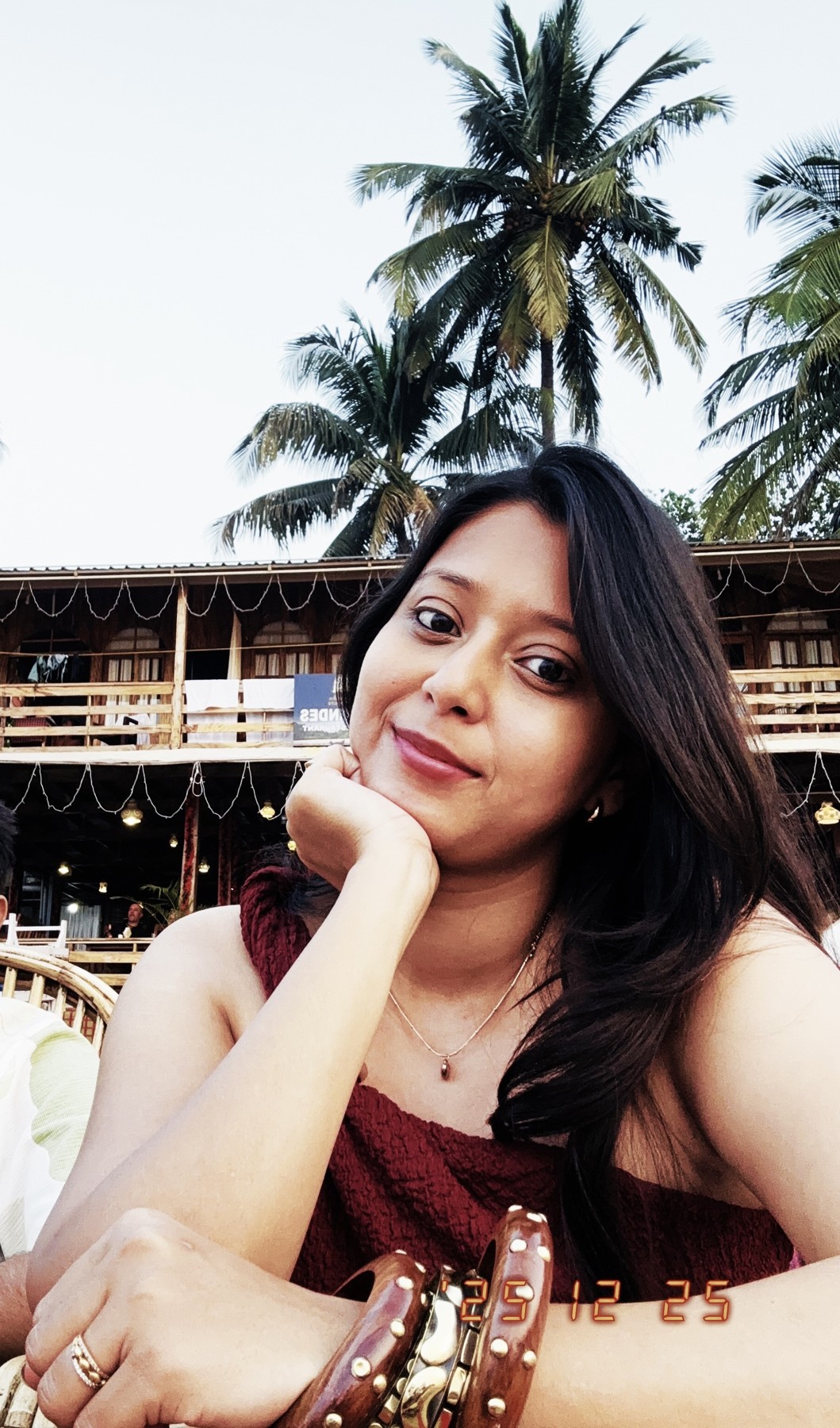 Kinjal smiling beneath palm trees